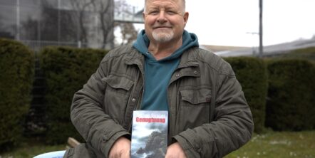 Ein Mann hält ein Buch in den Händen.