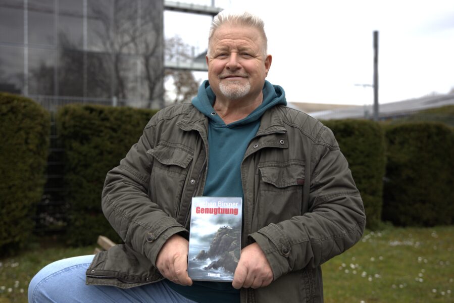 Ein Mann hält ein Buch in den Händen.