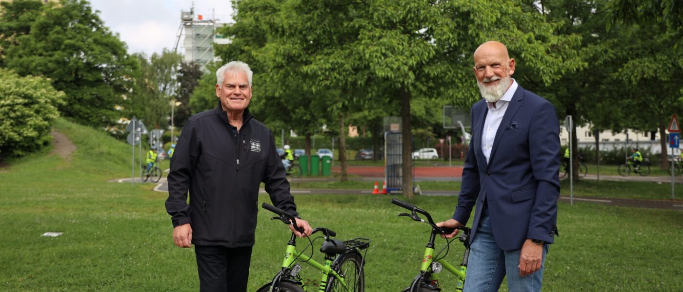 Zwei Männer stehen neben zwei Fahrrädern
