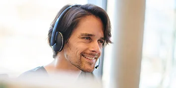 Porträt eines lächelnden Mannes mit Headset.